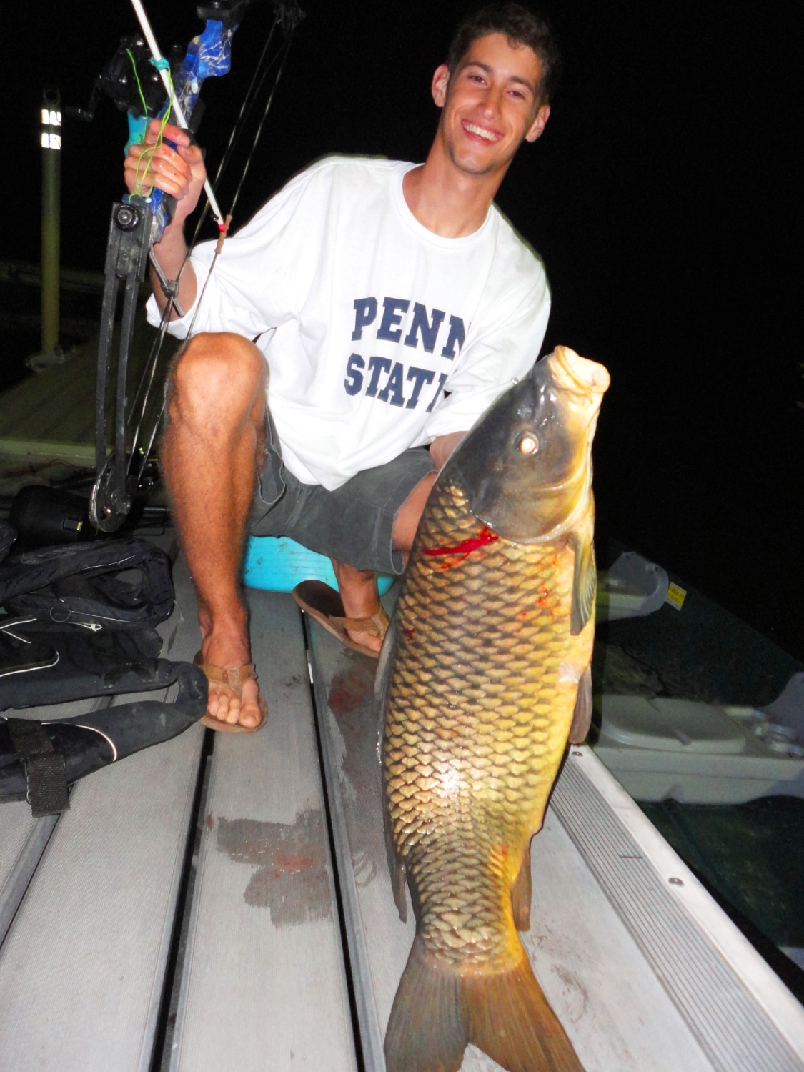 angler posing with a carp caught bowfishing. 