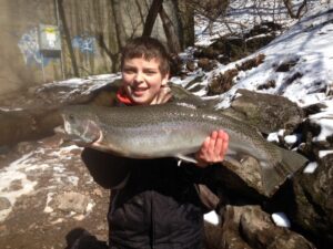 Ethan holds up a large steelhead trout. 