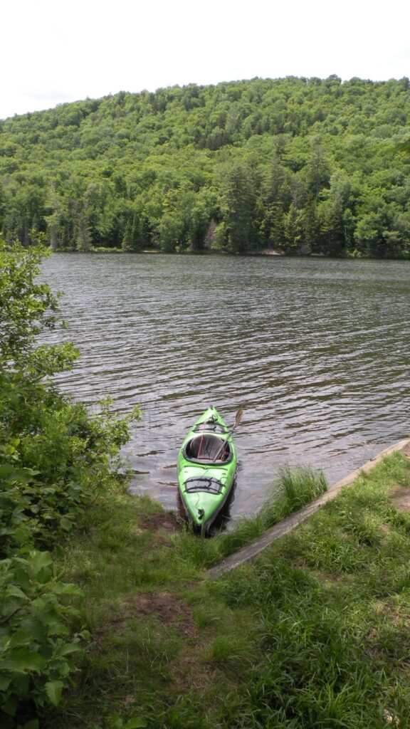 A fishing kayak sitting unmanned in the water. 
