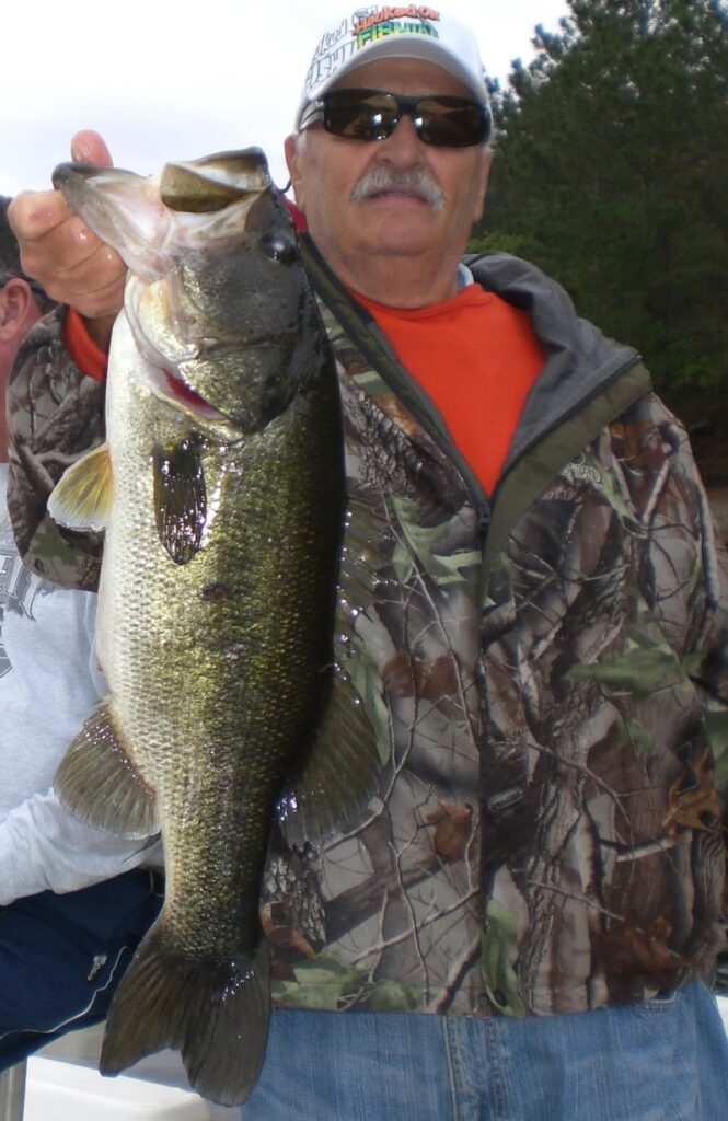  A fisherman lip holds a largemouth bass. 