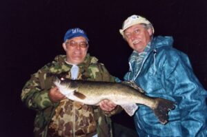 Two men showcase their trophy walleye. 