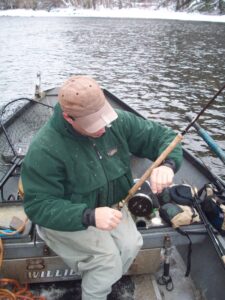 Fisherman setups a centerpin fly fishing reel while out on a boat.
