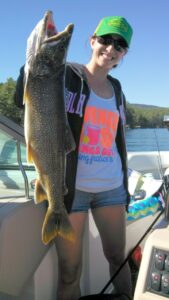 A happy angler holding out a lake trout.