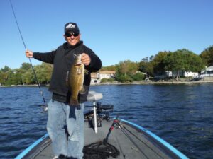 A happy angler lip grips a smallmouth bass showcasing it for the camera. 