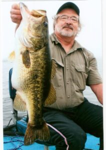A proud angler holds up a largemouth bass. 
