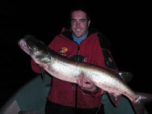 A happy angler holds out a large musky.