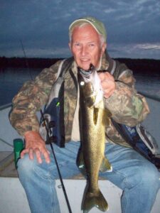 Angler holds out a walleye. 