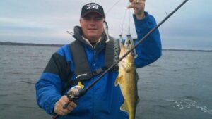 A professional angler holds out a walleye.