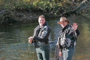 Two anglers wave for the camera as they practice their casting technique.