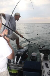 Fisherman attempt to land a big fish while drift fishing. 