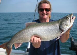 A lake Ontario angler holds up a large lake trout. 